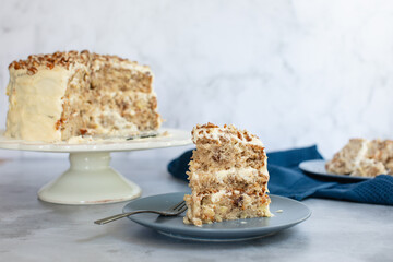 Three tier hummingbird or carrot cake with cream cheese frosting and pecan nuts or walnuts on a...