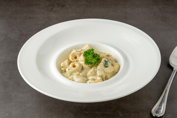 Delicious italian food tortellini pasta with mushroom cream sauce and cheese