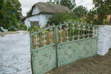 Old abandoned house in the village
Old iron gate in the yard of a country house. Green metal gate.