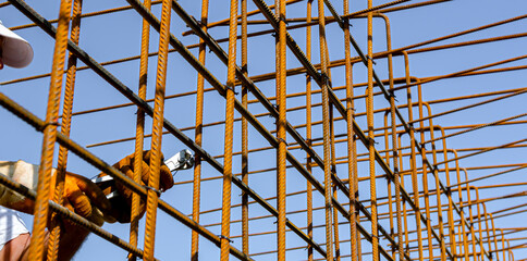 Construction worker binding rebar for reinforce concrete column at the building site.
