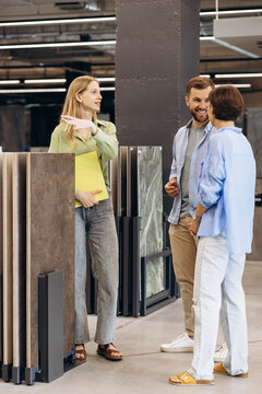 Couple talking to sales woman at building market choosing tile for their home