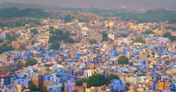 Houses of famous tourist landmark Jodhpur, the Blue City and birds, view from Mehrangarh Fort, Rajasthan, India. Camera zoom in