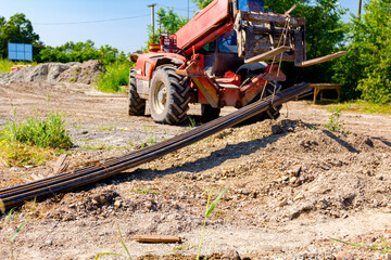 Forklift lifts the rebar bundle from ground on building site