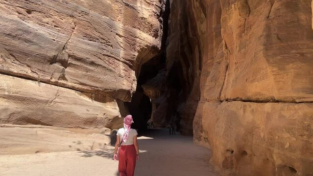 Tall Women walking in Petra in Wadi Musa, close to the Treasury of Jordan with no other people around 4K. Establish shot . World heritage side in UNESCO
