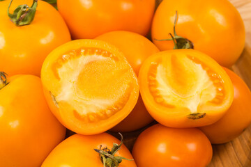 Halves of yellow tomato lie on the same whole tomatoes