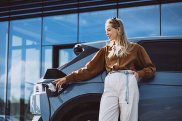 Business woman charging electric car