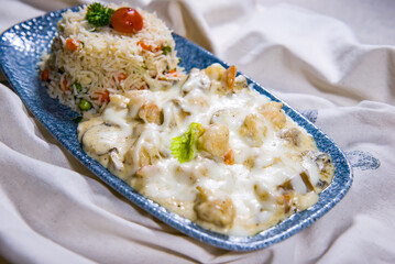 Chicken Bechamel Sauce or white sauce with vegetable fried rice served in dish isolated on food table top view of middle east spices