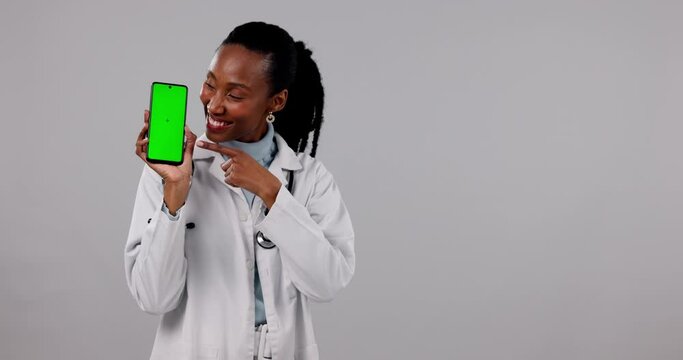 Black woman, doctor and pointing to phone with green screen in advertising against a studio background. Portrait of African female person or healthcare show mobile smartphone app, display or mockup