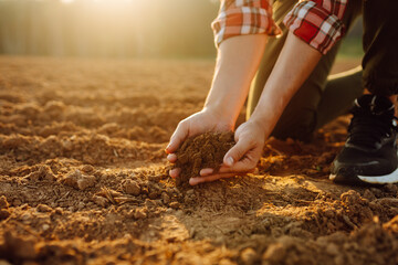 Farmer's hands check the quality and health of the soil before sowing. Concept of gardening, ecology.