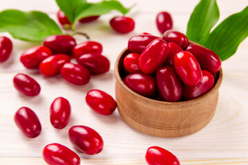 Cornela berries, on a white wooden background. Dogwood berries.