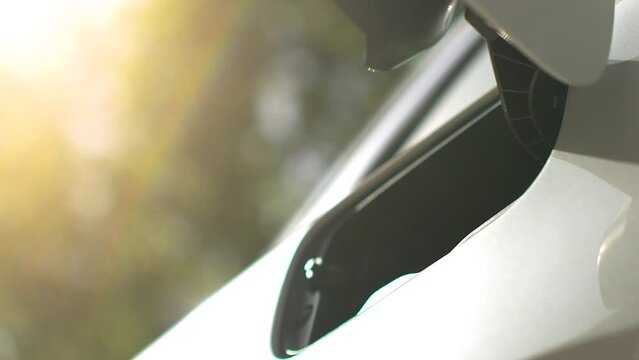 Power supply for electric car charging. Electric car charging station. Close up of the power supply plugged into an electric car being charged.