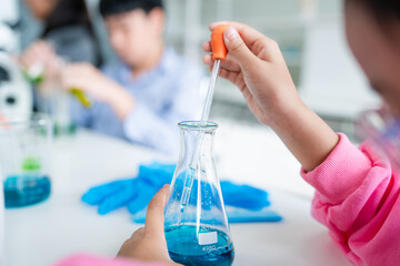 Closeup hand young schoolgirls learning research and doing experiment in chemistry classroom. Fun...