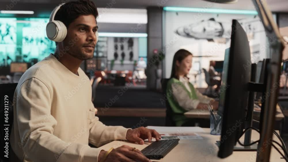 Fototapete Indian Male Game Developer Using Desktop Computer With 3D modelling Software To Design Characters And World For Immersive RPG Video Game. Creative Man Working In Game Design Company Diverse Office.