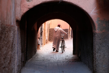 Man with bike in Marrakesh medina (old city), Morocco. - obrazy, fototapety, plakaty