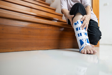 Leg of old elderly wearing foot support or ankle brace to protect the injured area,senior woman...