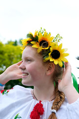 beautiful red-haired Ukrainian girl in an embroidered blouse flowers red poppies on a white shirt...