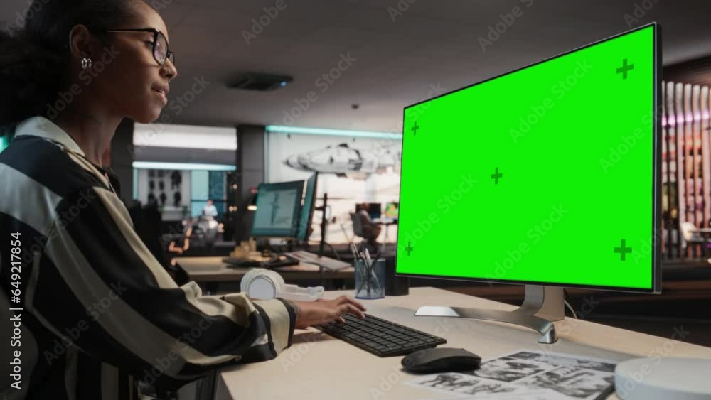 Poster Creative Black Woman Using Desktop Computer with Mock-up Green Screen Chromakey. Female VFX Artist Working in Game Development Company, Creating Immersive Gameplay Elements For Adventure Video Game.
