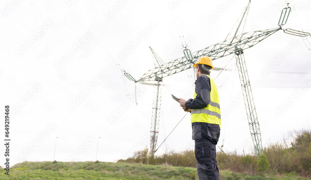 Aufkleber Engineer with digital tablet on a background of power line tower.
