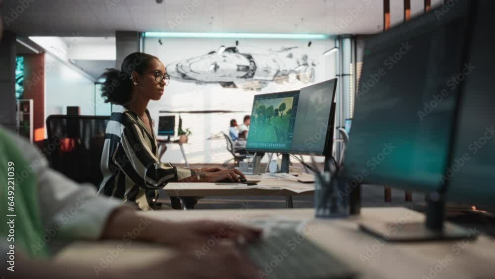 Poster Focus on Female Black Game Developer Using Desktop Computer With 3D Modeling Software To Create Immersive Game World In Office. On Foreground: Asian Woman Writes Lines Of Code For Gameplay Engineering