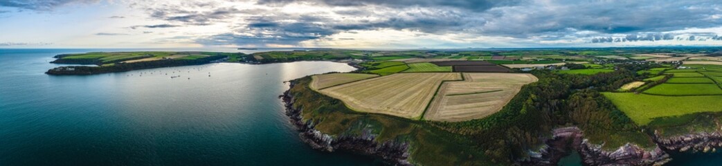 Fototapeta premium Panorama of Sunset over Fields and Farms from a drone, Monk Haven Beach, Pembrokeshire Coast Path, Haverfordwest, Wales, England