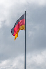 Cover page with national black red yellow flag of Germany and at dramatic sky with copy space. Concept of nationality, citizenship and economical crisis and recession