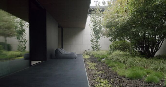 Exterior veranda of modern cottage house with comfort bean bag chairs and garden view. Lounge armchairs on terrace outdoors