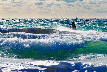 Kite surfer riding waves. Kiteboarding sport.