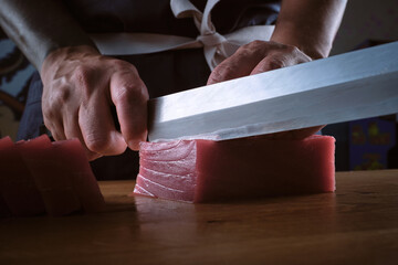 Male hands of a chef cutting a delicious loin of fresh bluefin t