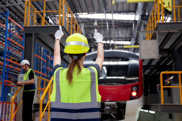 Young caucasian engineer woman or worker signal while engineer man checking electric train for...