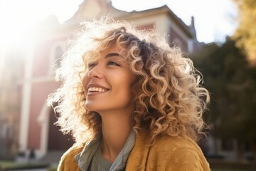 Portrait of beautiful young woman with curly hair in the city.