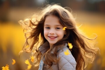 Portrait of a beautiful little girl with long hair in autumn park