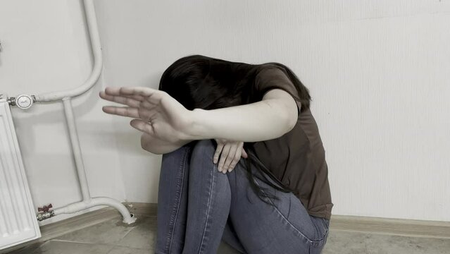 Girl sits on the floor near the battery. Day Against Humiliation. International Day Of Human Fraternity. World Day Against Social Inequality. World Day Against Trafficking in Persons