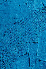 Decorative blue putty background. Wall texture with filler paste applied with spatula, chaotic dashes and strokes over plaster. Creative design, stone pattern, cement.