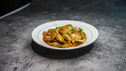 Delicious Batik Clam Served with Sauce on a White Plate 