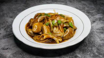 Delicious Batik Clam Served with Sauce on a White Plate 