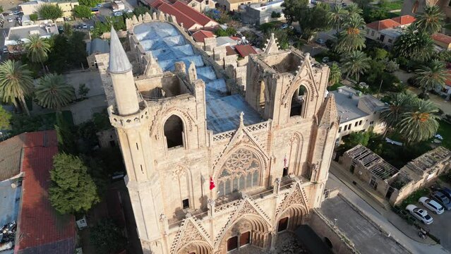 Tilting aerial view of beautiful gothic cathedral, with an added minaret on the side. Now Lala Mustafa mosque. Architecture and historic landmark in Famagusta, Northern Cyprus. 
