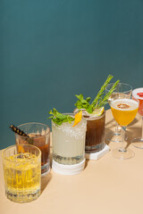 Composition with alcoholic cocktails on podiums on colored background. Signature cocktails still life