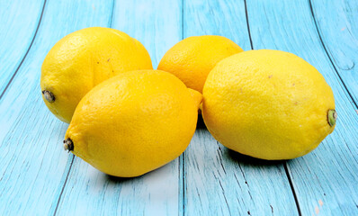 Juicy ripe yellow lemons on a blue wood table