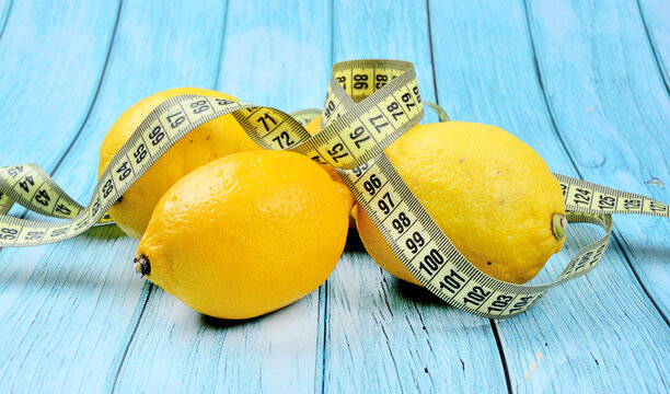 Fresh lemons with centimeter on a blue wood table