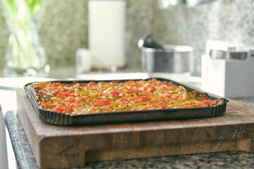 Assorted pizza with tomatoes and peppers placed on tray