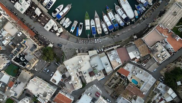 Overhead drone flight of fishing and traditional boats in the beautiful harbor of Kyrenia, a popular travel destination in Northern Cyprus, Europe
