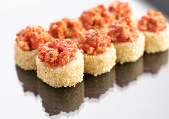 Baked Sushi rolls on white background with reflection, space for text. Japanese food