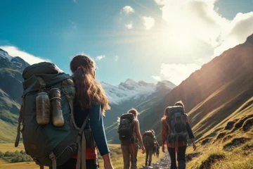 Fotobehang young woman hikker wearing backpak looking at the mountains in background of green landscape and beautiful sky. travel concept of vacation and holiday. © cwa
