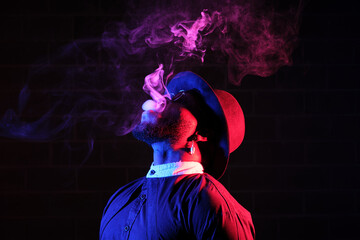Brutal man smoking on dark background