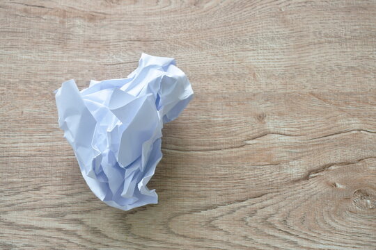 crumple white paper throw on wooden table