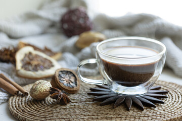 Composition with a cup of coffee on a blurred background with a knitted element.