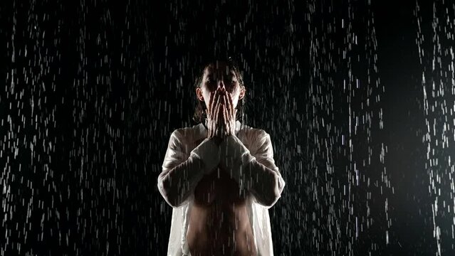 sexy lady in wet white shirt standing in rain in night, portrait of sensual woman with naked breasts