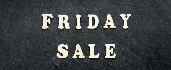 Wooden text Black friday sale on black textured background, top view.