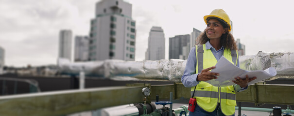 Civil engineer woman dark skin wearing uniform and safety helmet under inspection and checking plan...