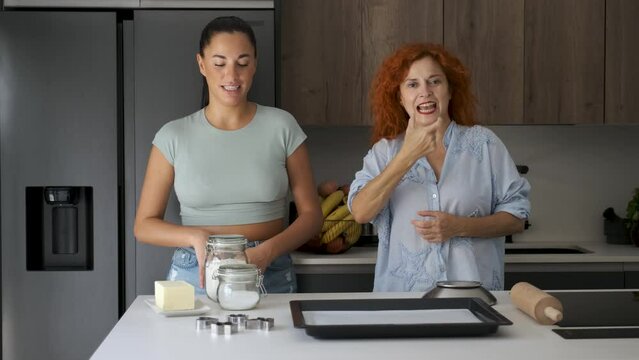 Mother and daughter explaining butter cookies recipe with sign language.